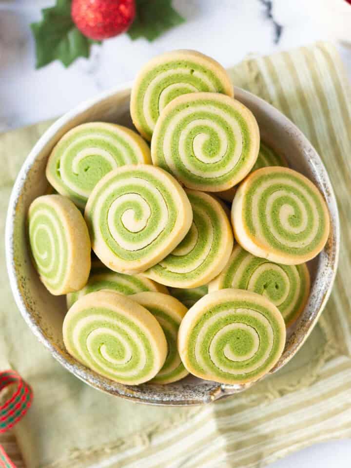 matcha pinwheel cookies in a bowl on a green napkin.