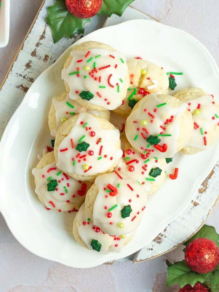 almond ricotta cookies with sprinkles on top on a white platter.