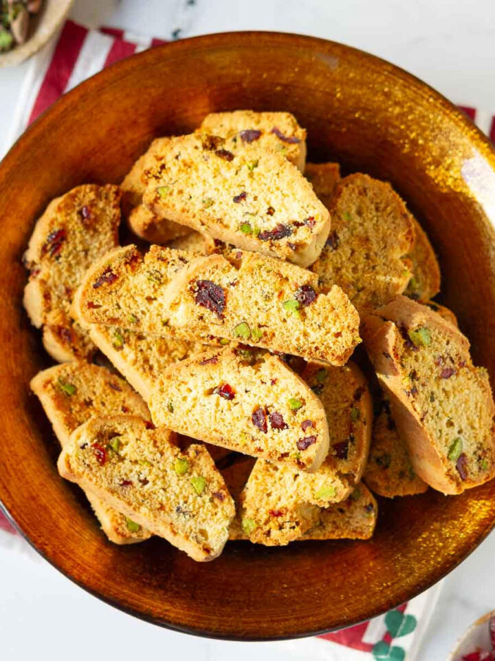 cranberry pistachio biscotti in a golden serving bowl.